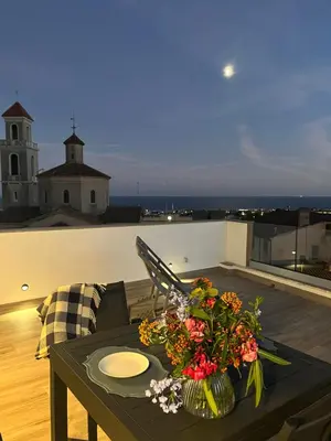 a table with a vase of flowers on a balcony at Ses Voltes Boutique Home Sea and Sky in Vilassar de Dalt