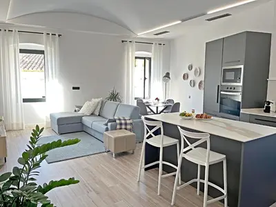 a kitchen and living room with a couch and a table at Ses Voltes Boutique Home Sea and Sky in Vilassar de Dalt
