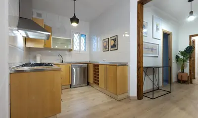 a kitchen with wooden cabinets and a counter top at Stay U-nique Apartment Gran Via IV in Barcelona