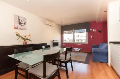 a kitchen and living room with a table and chairs at Rambla Suites in Barcelona