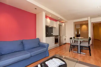 a living room with a blue couch and a table at Rambla Suites in Barcelona