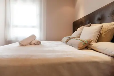 a large bed with two pillows on top of it at Espectacular piso cerca de la playa in Barcelona