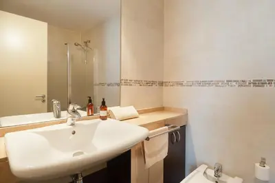 a white bathroom with a sink and a toilet at Espectacular piso cerca de la playa in Barcelona