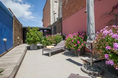 a patio with flowers and a bench next to a building at Tendency Apartments 7 in Barcelona