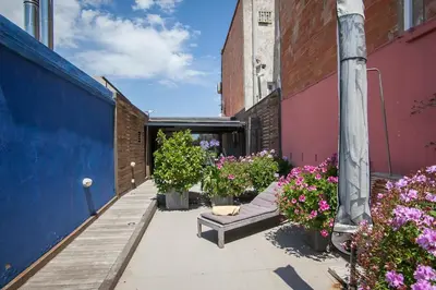 a patio with flowers and a couch in a courtyard at Tendency Apartments 7 in Barcelona
