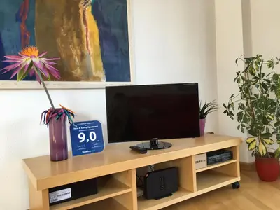 a desk with a television and a clock on it at New & Sunny Apartment in Barcelona
