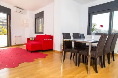a living room with a table and a red couch at New & Sunny Apartment in Barcelona
