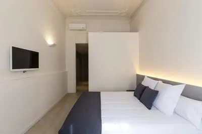 a bedroom with a bed with a tv on the wall at Izaila Plaza Catalunya in Barcelona