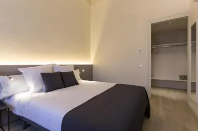 a bedroom with a large bed with white sheets and pillows at Izaila Plaza Catalunya in Barcelona
