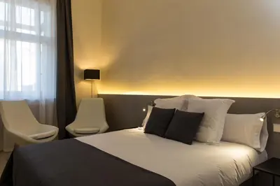 a bedroom with a bed with two chairs and a window at Izaila Plaza Catalunya in Barcelona