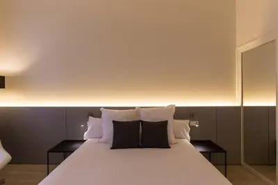 a bedroom with a white bed with black pillows at Izaila Plaza Catalunya in Barcelona