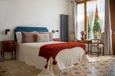 a bedroom with a bed and a table and a window at Bell Plançó B&B in Moià
