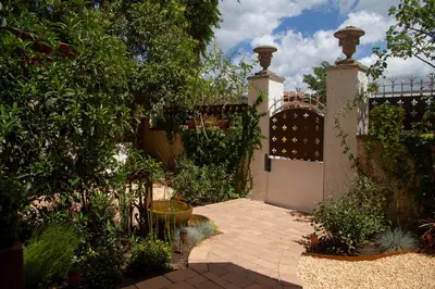 a garden with a gate and a brick walkway at Bell Plançó B&B in Moià