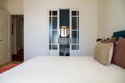 a bedroom with a white bed and a mirror at Bell Plançó B&B in Moià