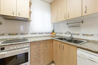 a kitchen with white cabinets and a sink at LetsGo Sagrada Familia Penthouse in Barcelona