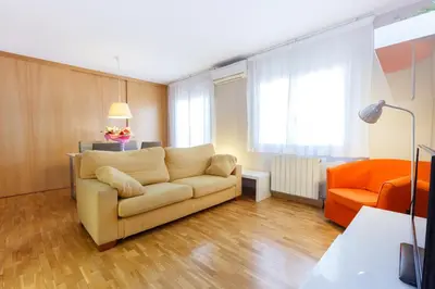 a living room with a couch and an orange chair at LetsGo Sagrada Familia Penthouse in Barcelona