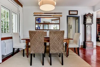 a dining room with a table and chairs and a clock at Casa en Sitges in Sitges