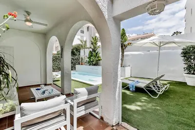 an outdoor patio with chairs and an umbrella at Casa en Sitges in Sitges