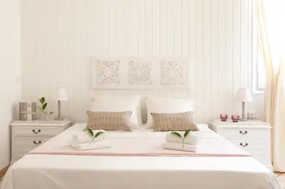 a white bedroom with a large white bed with two night stands at Casa Muntaner in Barcelona