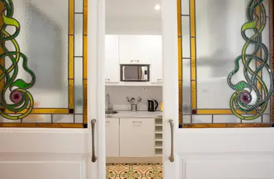 a kitchen with stained glass windows and a kitchen counter at Casa Muntaner in Barcelona