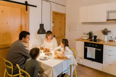a family sitting at a table in a kitchen at Ca l'Espavil in Cardedeu