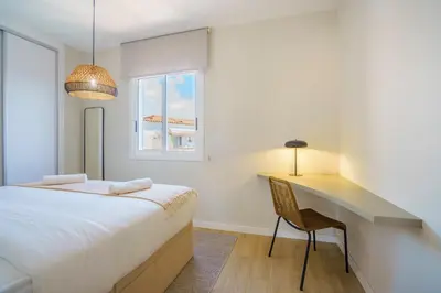 a bedroom with a bed and a desk and a window at Sitges Spaces Mediterranean Penthouse in Sitges