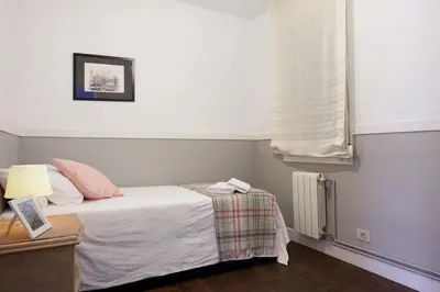 a small bedroom with a bed and a window at Letsgo Camp Nou Apartment in Barcelona