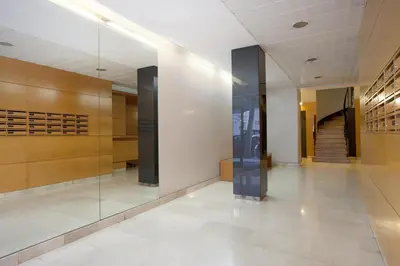 a hallway of a building with a glass elevator at Letsgo Camp Nou Apartment in Barcelona