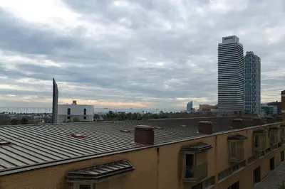 a view of a rooftop of a building with a skyscraper at Alcam Vila Olímpica in Barcelona