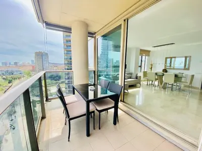 a dining room with a table and chairs on a balcony at Akira Flats Diagonal Mar Apartments in Barcelona