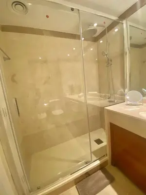 a glass shower in a bathroom with a sink at Akira Flats Diagonal Mar Apartments in Barcelona