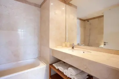 a bathroom with a sink and a tub and a mirror at Akira Flats Diagonal Mar Apartments in Barcelona