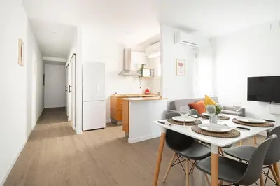 a kitchen and living room with a table and chairs at APARTMENT BEACH PICASSO in Sant Adria de Besos