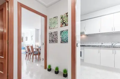 a kitchen and dining room with white cabinets and potted plants at Fantástico apartamento en la playa. A/A y vistas in Pineda de Mar