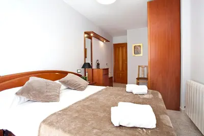 a bedroom with a bed with two white towels on it at Fantástico apartamento en la playa. A/A y vistas in Pineda de Mar