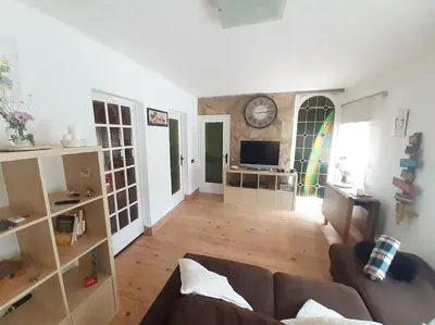 a living room with a couch and a clock on the wall at Maresme´s corner in Sant Andreu de Llavaneres