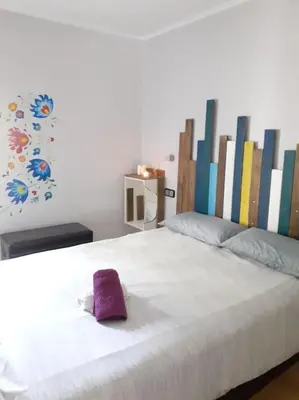 a white bed with a purple towel on it at Maresme´s corner in Sant Andreu de Llavaneres