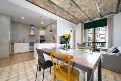 a kitchen and living room with a table and chairs at Apartamento moderno en Sant Antoni in Barcelona