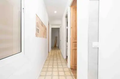 a hallway with white walls and a tiled floor at Apartamento moderno en Sant Antoni in Barcelona
