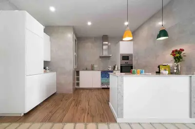 a large kitchen with white cabinets and a counter at Apartamento moderno en Sant Antoni in Barcelona