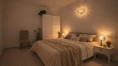a bedroom with a large bed with two lamps and a chair at Tranquil Duplex Sitges, sea views, private parking, terrace in Sitges