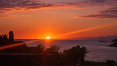 a sunset over the water with the sun in the sky at Tranquil Duplex Sitges, sea views, private parking, terrace in Sitges