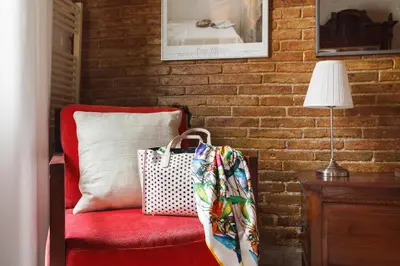 a red chair with a pillow and a bag on it at The Patio Barcelona in Barcelona