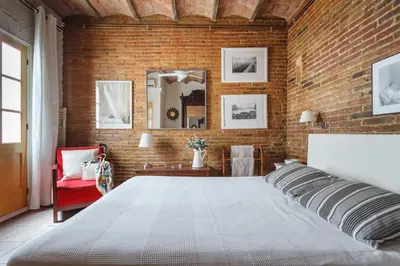 a bedroom with a large bed and a brick wall at The Patio Barcelona in Barcelona