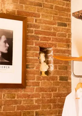 a brick wall with a picture and a bust on it at The Patio Barcelona in Barcelona