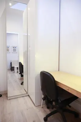 an office with a wooden desk and a mirror at Cozy near the Barcelona Camp Nou Stadium in Barcelona