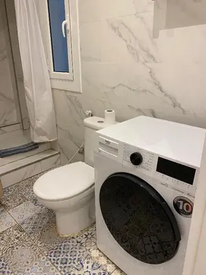 a bathroom with a toilet and a washing machine at Cozy near the Barcelona Camp Nou Stadium in Barcelona