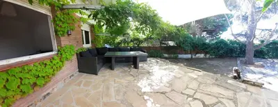 a patio with a couch and a tv on a building at Caldetas in Caldes d'Estrac
