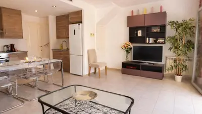 a kitchen and dining room with a table and a refrigerator at Modern Duplex in Sitges with Private Parking, Sea Views & Terrace in Sitges