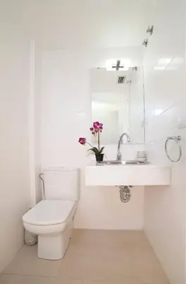 a white bathroom with a toilet and a sink at Modern Duplex in Sitges with Private Parking, Sea Views & Terrace in Sitges
